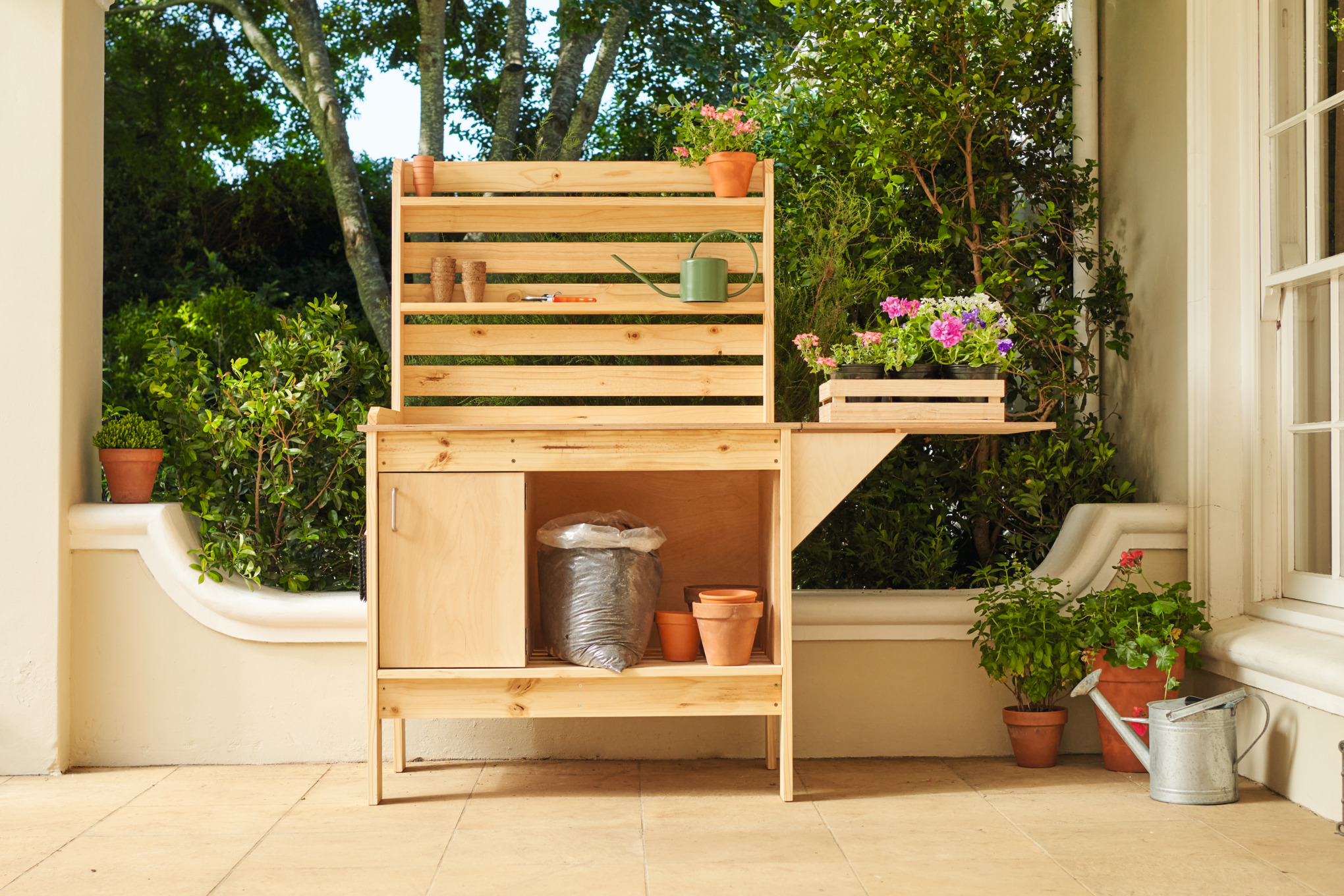 Table de jardinage en bois avec pots de fleurs dans la véranda