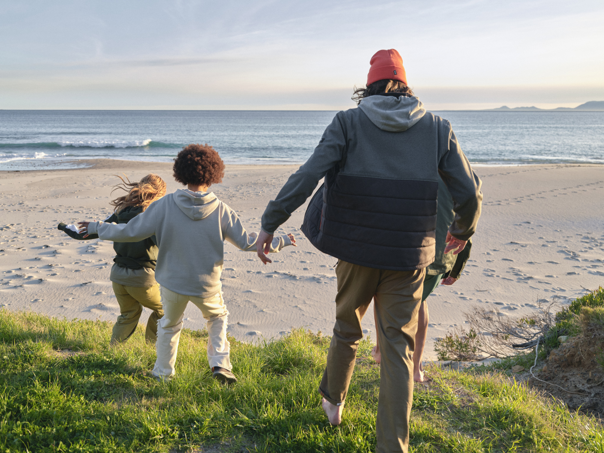 une famille se promène sur une plage avec des vêtements STIHL