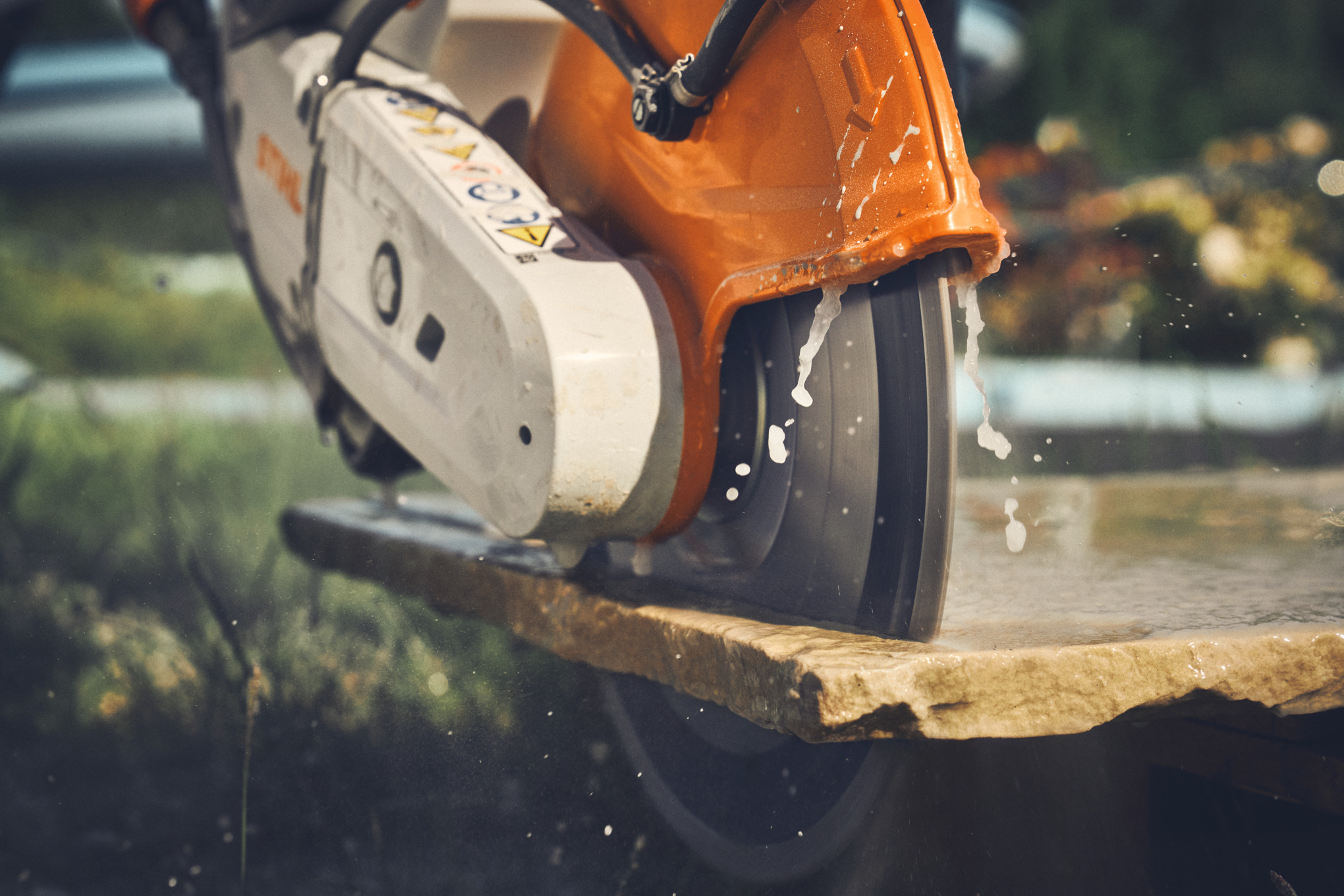 Gros plan sur la découpe de dalles de trottoir avec la tronçonneuse à batterie STIHL TSA 300.